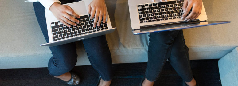 two women laptops sitting